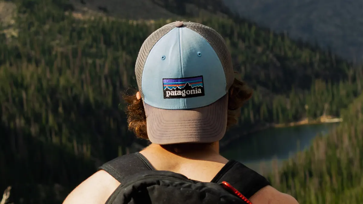 Back of man at the top of hiking hill wearing backwards Patagonia hat.